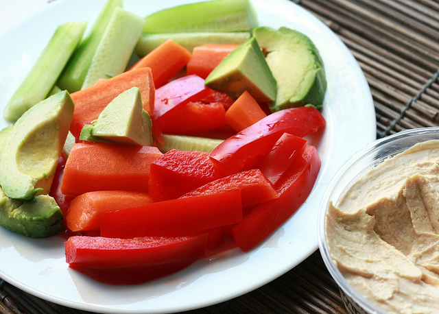 A plate of fresh vegetables and hummus.