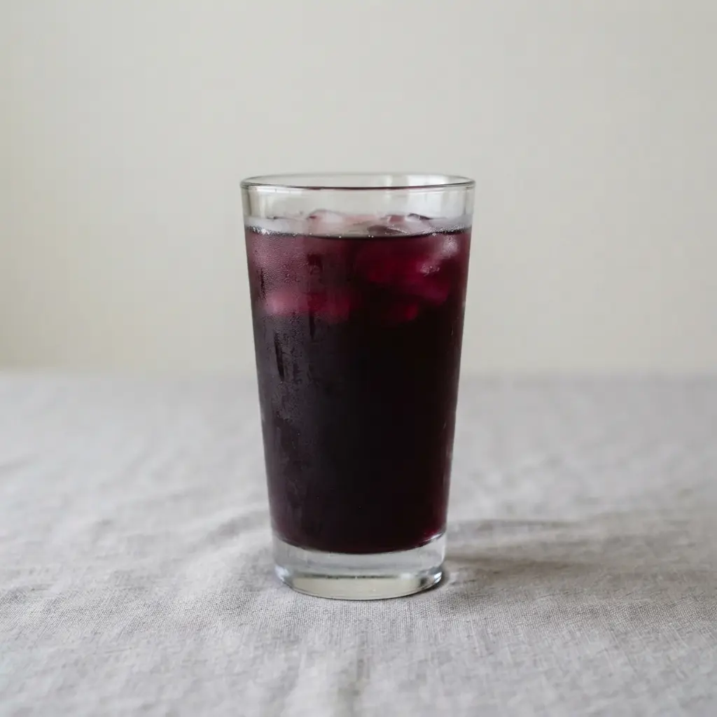 A dark, jewel-toned iced tea loaded with blackberries and fragrant sage leaves.