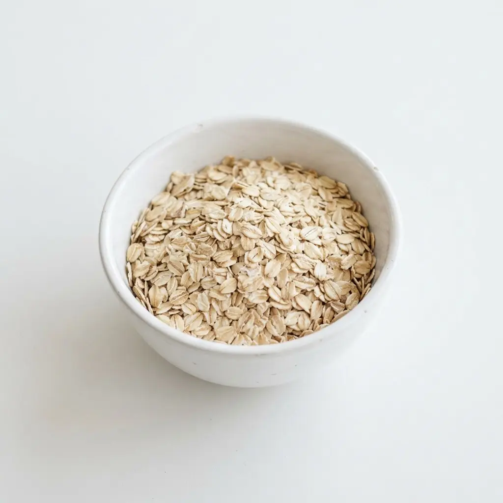 Rolled oats in a plain white bowl on a clean white background.