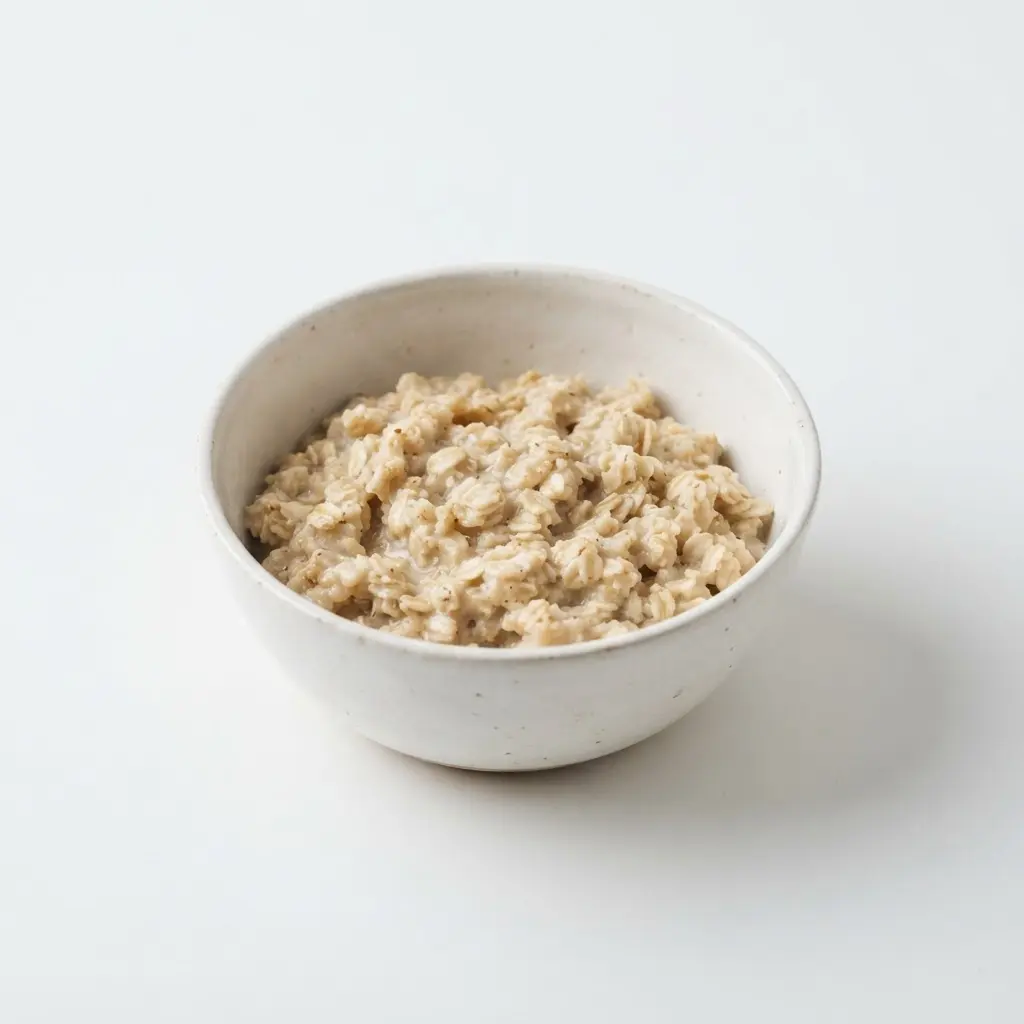 Rolled oats in a plain white bowl on a clean white background.