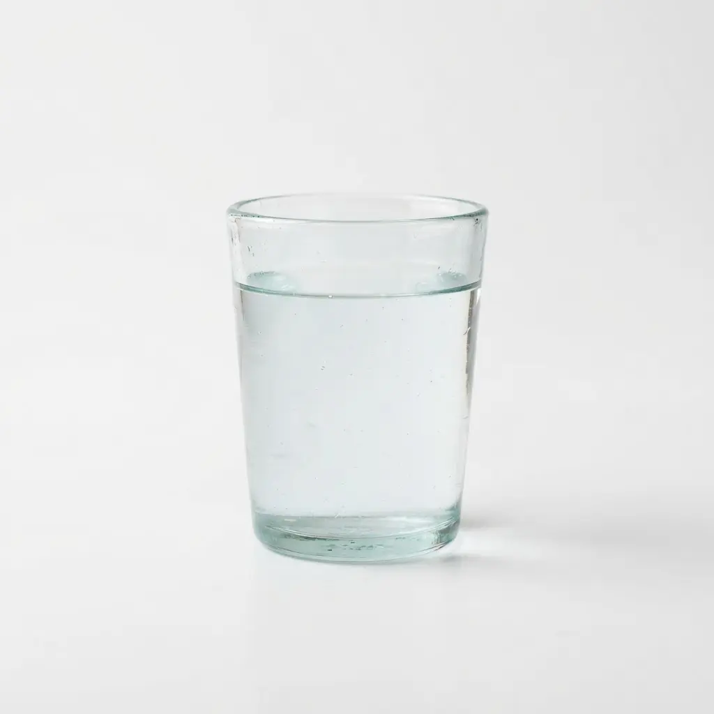 Water in a clear drinking glass on a clean white background.