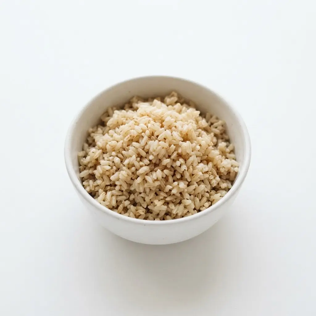 Brown rice in a plain white bowl on a clean white background.